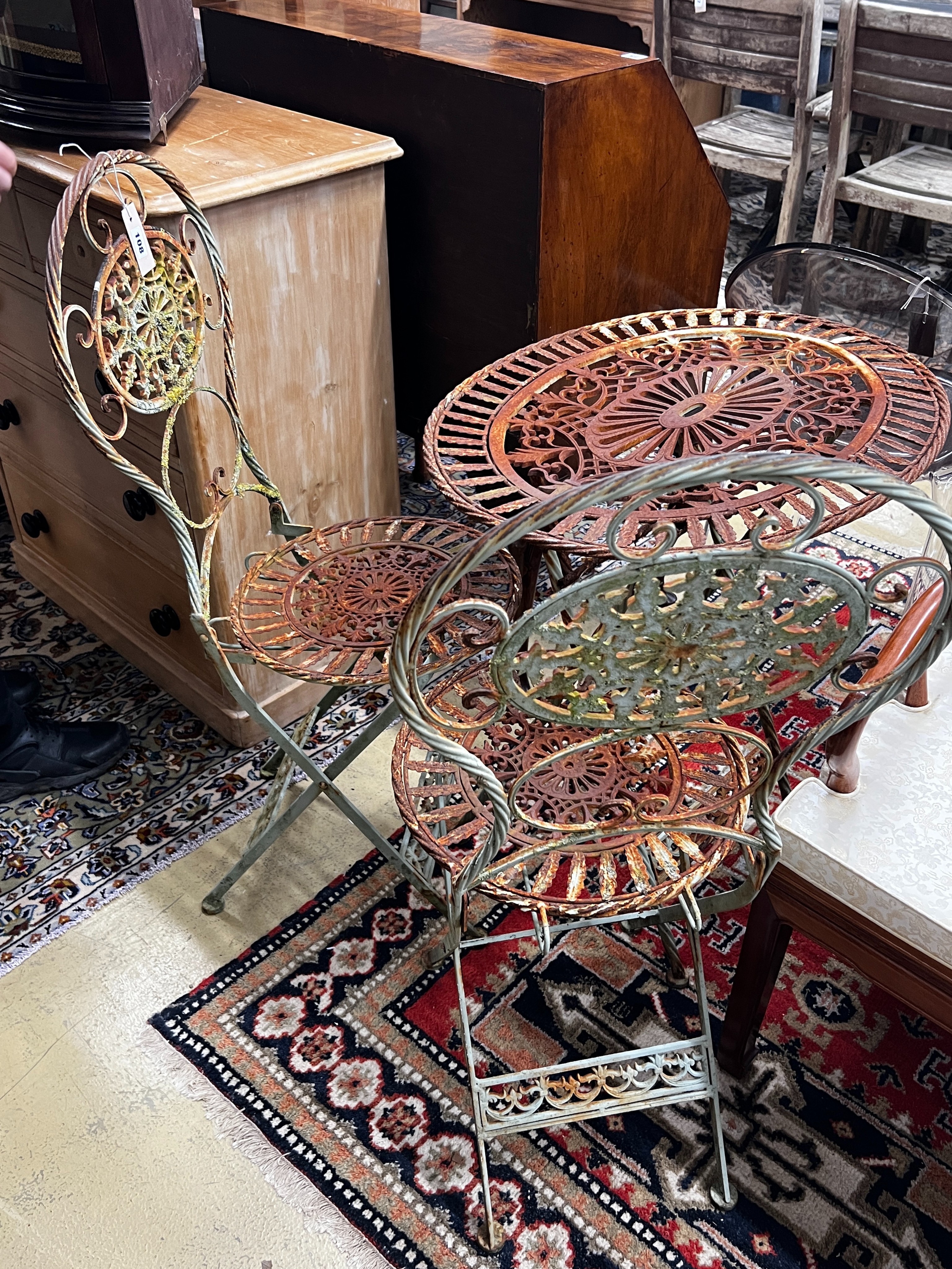 A painted oval folding wrought iron garden table, length 71cm, width 54cm, height 75cm together with two matching chairs